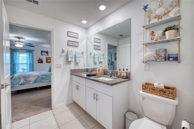 bathroom with vanity, ceiling fan, toilet, tile patterned floors, and a textured ceiling