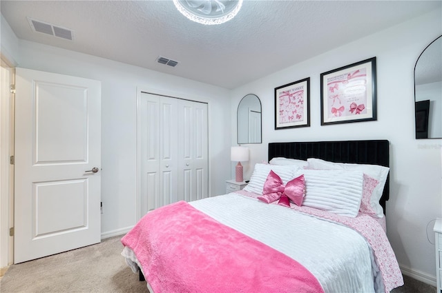 carpeted bedroom with a closet and a textured ceiling