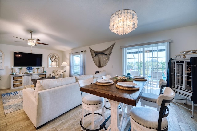 dining area featuring ceiling fan with notable chandelier and light hardwood / wood-style floors