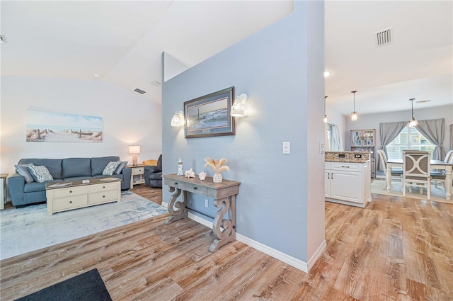 living room with lofted ceiling and light hardwood / wood-style flooring