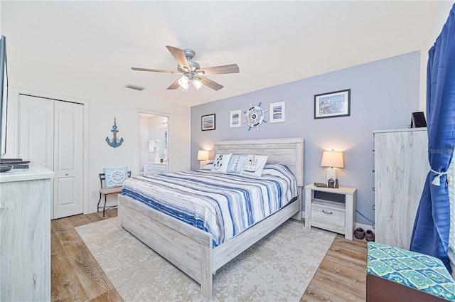 bedroom featuring ensuite bath, a closet, ceiling fan, and light wood-type flooring