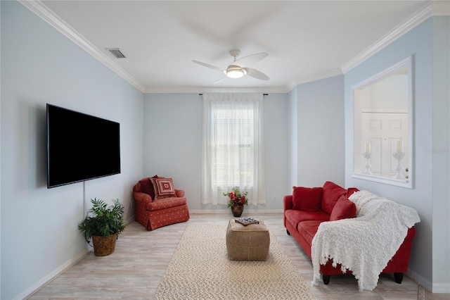 living room featuring crown molding, ceiling fan, and light wood-type flooring