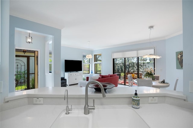 living room featuring ornamental molding, sink, and a notable chandelier