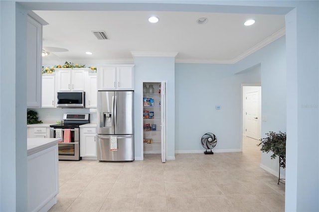 kitchen featuring ceiling fan, ornamental molding, stainless steel appliances, and white cabinets