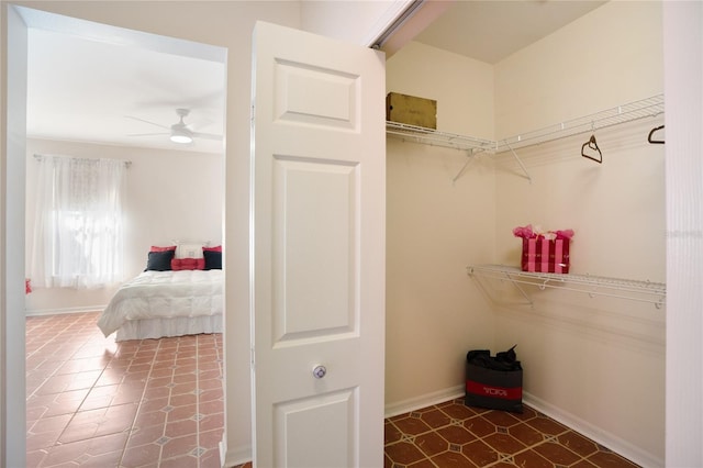 walk in closet featuring ceiling fan and dark tile patterned floors