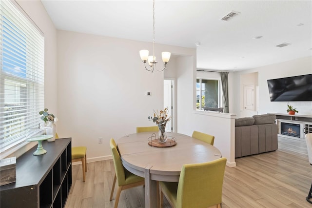 dining room with plenty of natural light, a chandelier, and light wood-type flooring