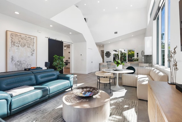 living room with high vaulted ceiling and a barn door