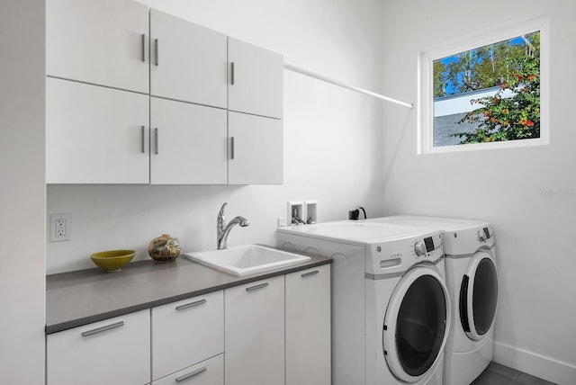 washroom featuring cabinets, washing machine and dryer, and sink