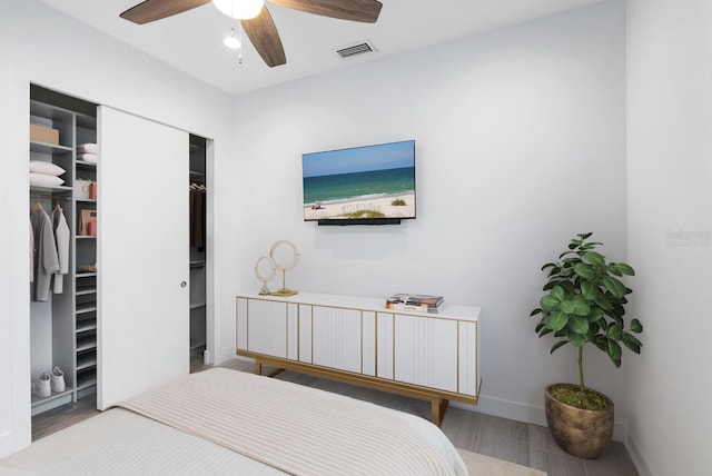 bedroom featuring hardwood / wood-style floors, ceiling fan, and a closet