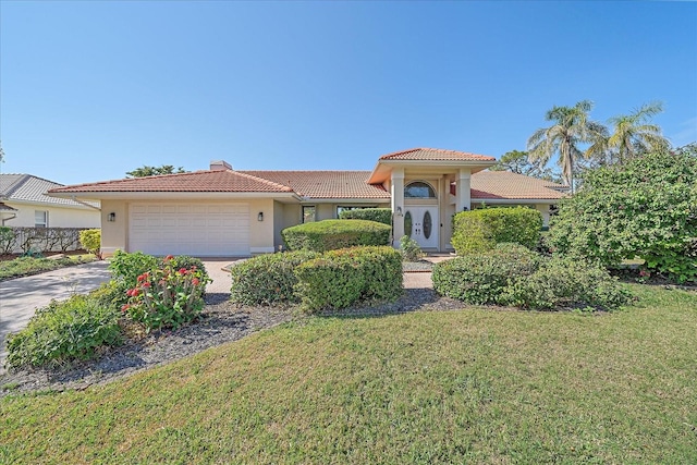 mediterranean / spanish house featuring a garage and a front lawn