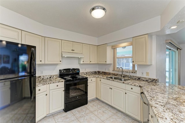 kitchen featuring sink, cream cabinets, black appliances, and light stone countertops