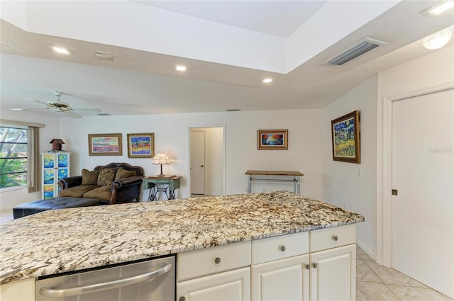 kitchen with white cabinetry, dishwasher, light tile patterned floors, light stone counters, and ceiling fan