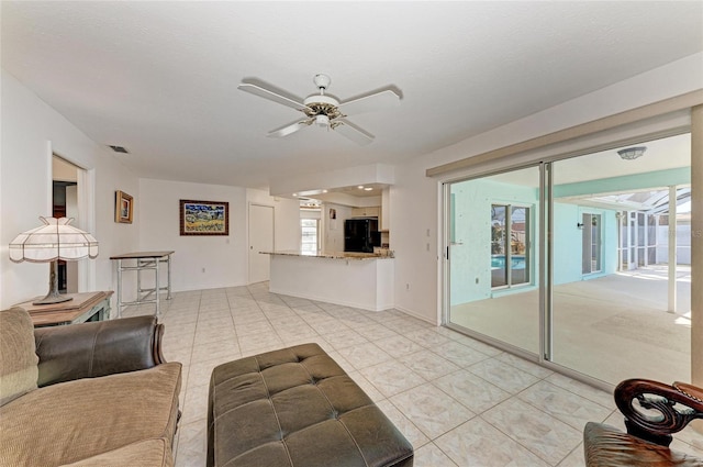 tiled living room featuring ceiling fan and a textured ceiling