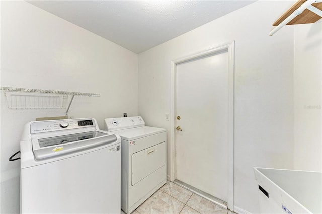 clothes washing area featuring separate washer and dryer and light tile patterned flooring