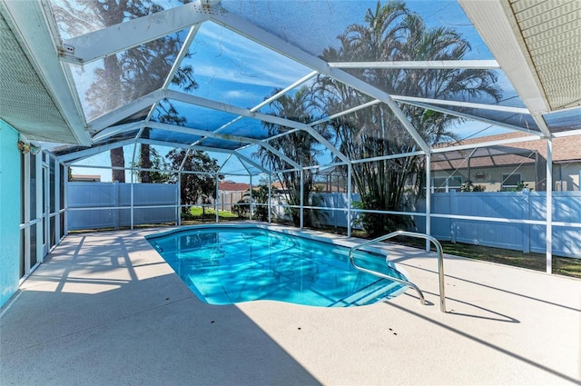 view of swimming pool featuring a patio area and glass enclosure