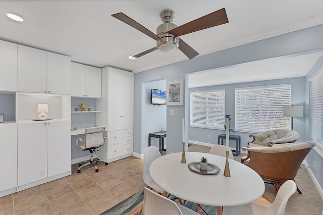 dining area featuring light tile patterned flooring, ceiling fan, crown molding, and built in desk