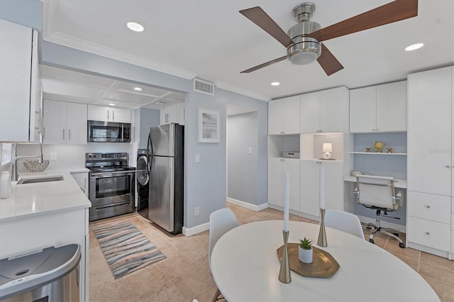 kitchen featuring ornamental molding, appliances with stainless steel finishes, sink, and white cabinets