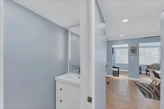 corridor featuring sink and light tile patterned floors