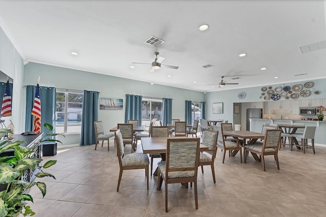 tiled dining space with crown molding and ceiling fan