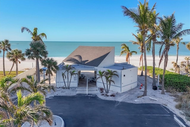 view of front of property with a water view and a view of the beach