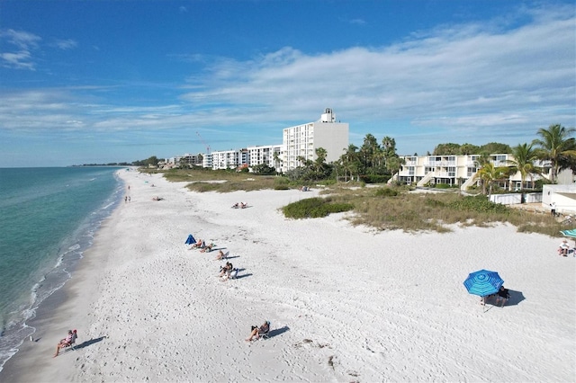 birds eye view of property featuring a water view and a beach view