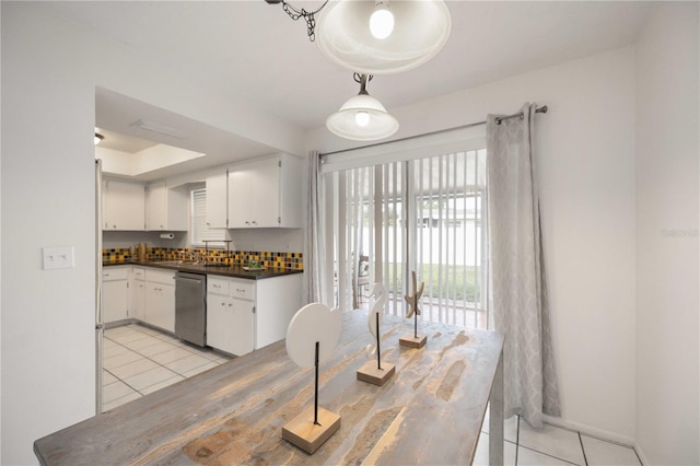 kitchen with hanging light fixtures, dishwasher, light tile patterned floors, and white cabinets