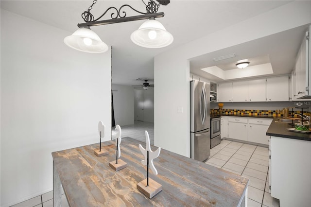 kitchen featuring sink, decorative light fixtures, a raised ceiling, stainless steel appliances, and white cabinets