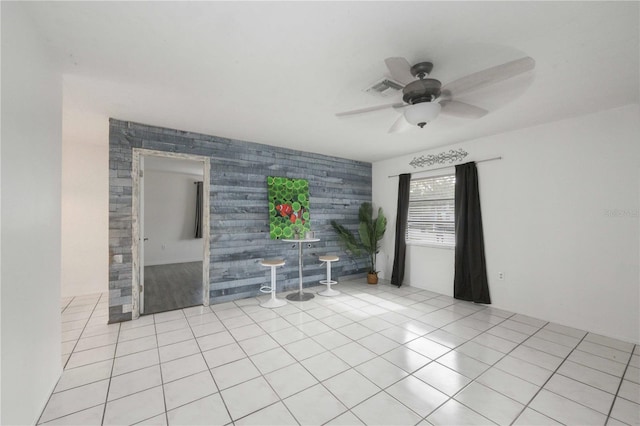 tiled empty room featuring ceiling fan