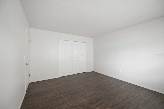 unfurnished bedroom featuring dark hardwood / wood-style flooring and a closet