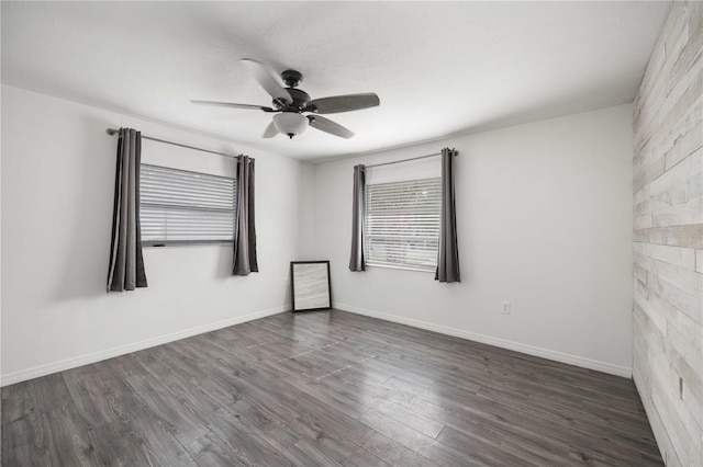 spare room featuring dark wood-type flooring and ceiling fan