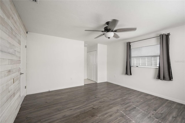 unfurnished room featuring dark wood-type flooring and ceiling fan