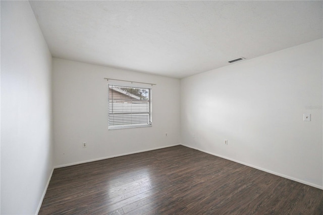 unfurnished room featuring dark hardwood / wood-style flooring