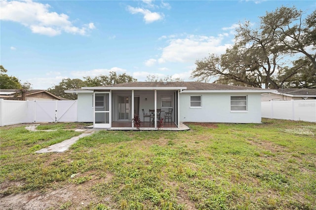 back of property featuring a sunroom and a yard