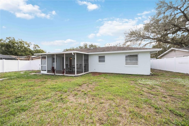 rear view of property with a yard and a sunroom