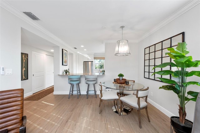 dining room featuring ornamental molding and hardwood / wood-style flooring