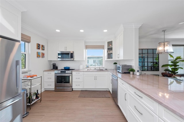 kitchen with white cabinetry, backsplash, appliances with stainless steel finishes, and sink