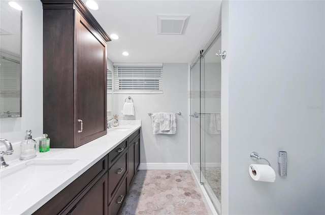 bathroom with vanity and a shower with door