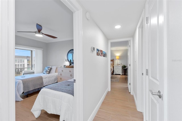 hallway with ceiling fan, ornamental molding, and light hardwood / wood-style floors