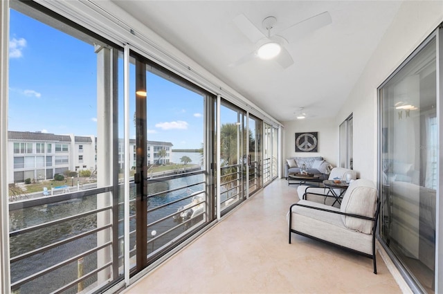 sunroom / solarium with a water view and ceiling fan