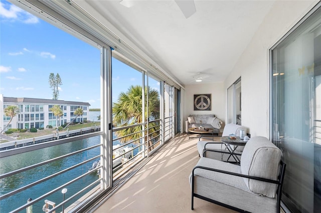 sunroom / solarium featuring ceiling fan, a water view, and a wealth of natural light