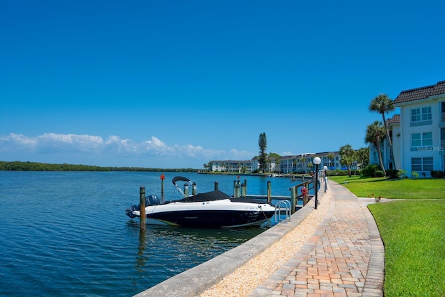 view of dock with a water view and a lawn