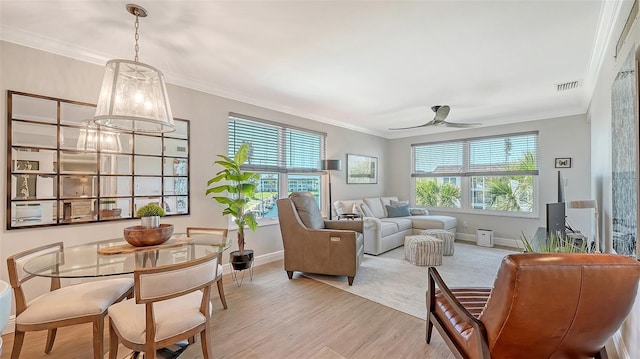 living area with plenty of natural light, baseboards, and light wood-type flooring