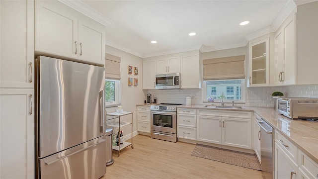 kitchen with white cabinetry, appliances with stainless steel finishes, decorative backsplash, and a sink