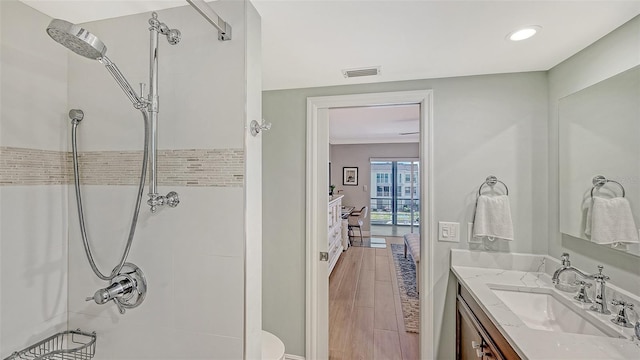 bathroom featuring walk in shower, vanity, visible vents, and recessed lighting