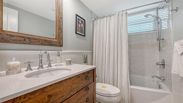 full bathroom featuring a wainscoted wall, shower / bath combination with curtain, vanity, and toilet