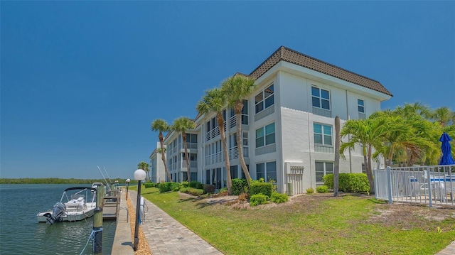 view of building exterior with fence and a water view