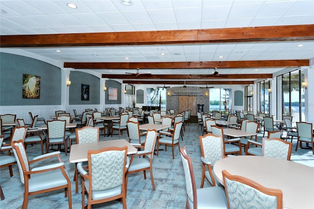 dining space with a wainscoted wall, beam ceiling, and recessed lighting