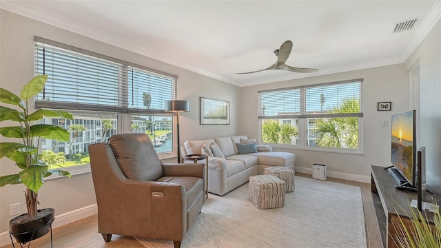 living area with light wood finished floors, baseboards, and crown molding
