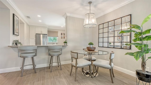 dining room with light wood-style floors, visible vents, and baseboards