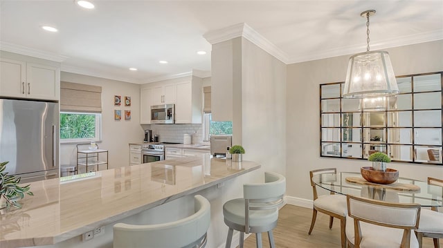 kitchen featuring white cabinets, backsplash, light wood-style floors, light stone counters, and appliances with stainless steel finishes